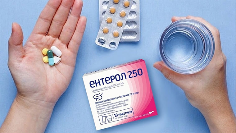 Композиція на блакитному фоні: упаковка Ентерол 250, склянка води, блістер та долоня з різними капсулами.